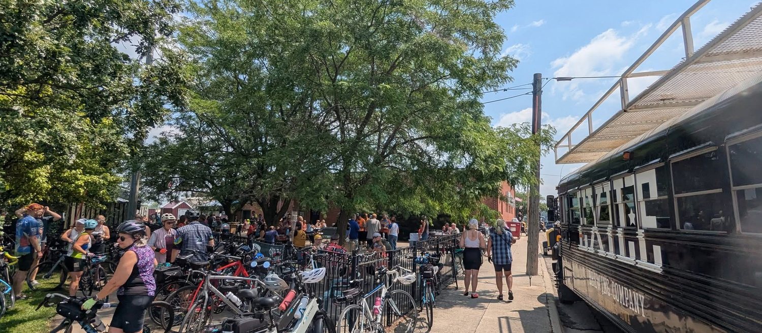 Cyclists, bikes, and the Exile brewing bus packed onto Benola's patio on the Chichaqua Valley Trail